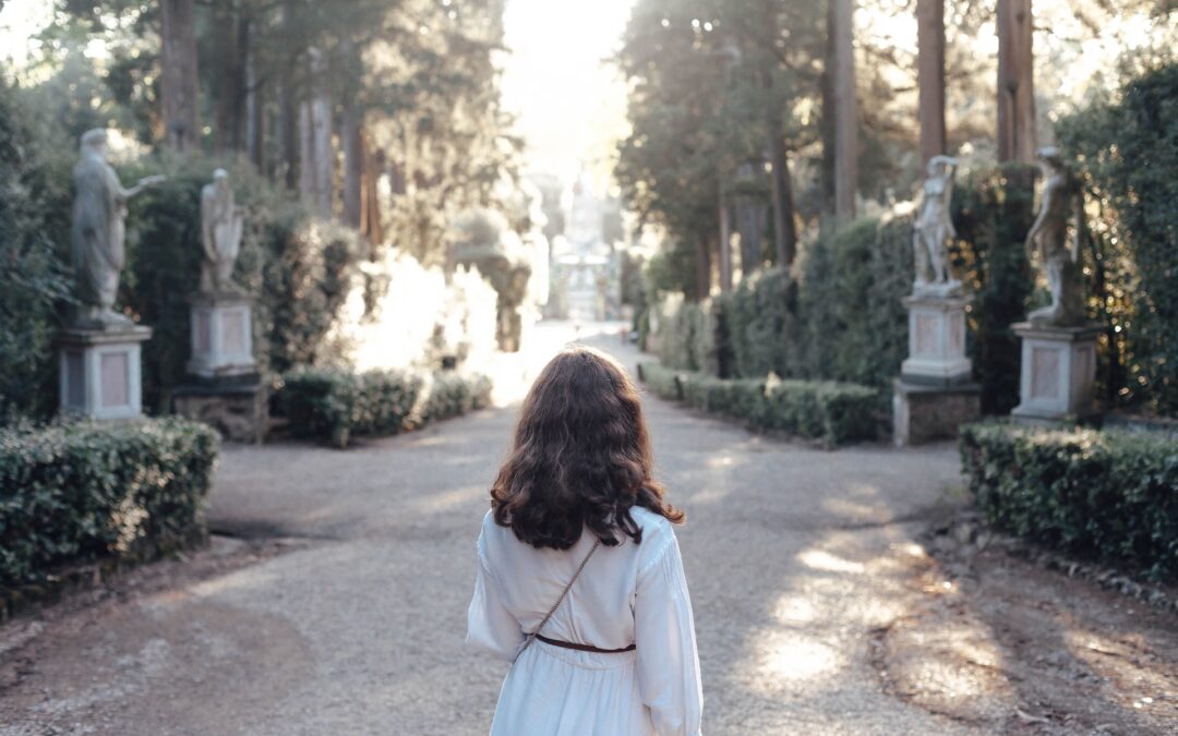 Girl walking in Boboli Gardens in Florence in a white dress in the summer