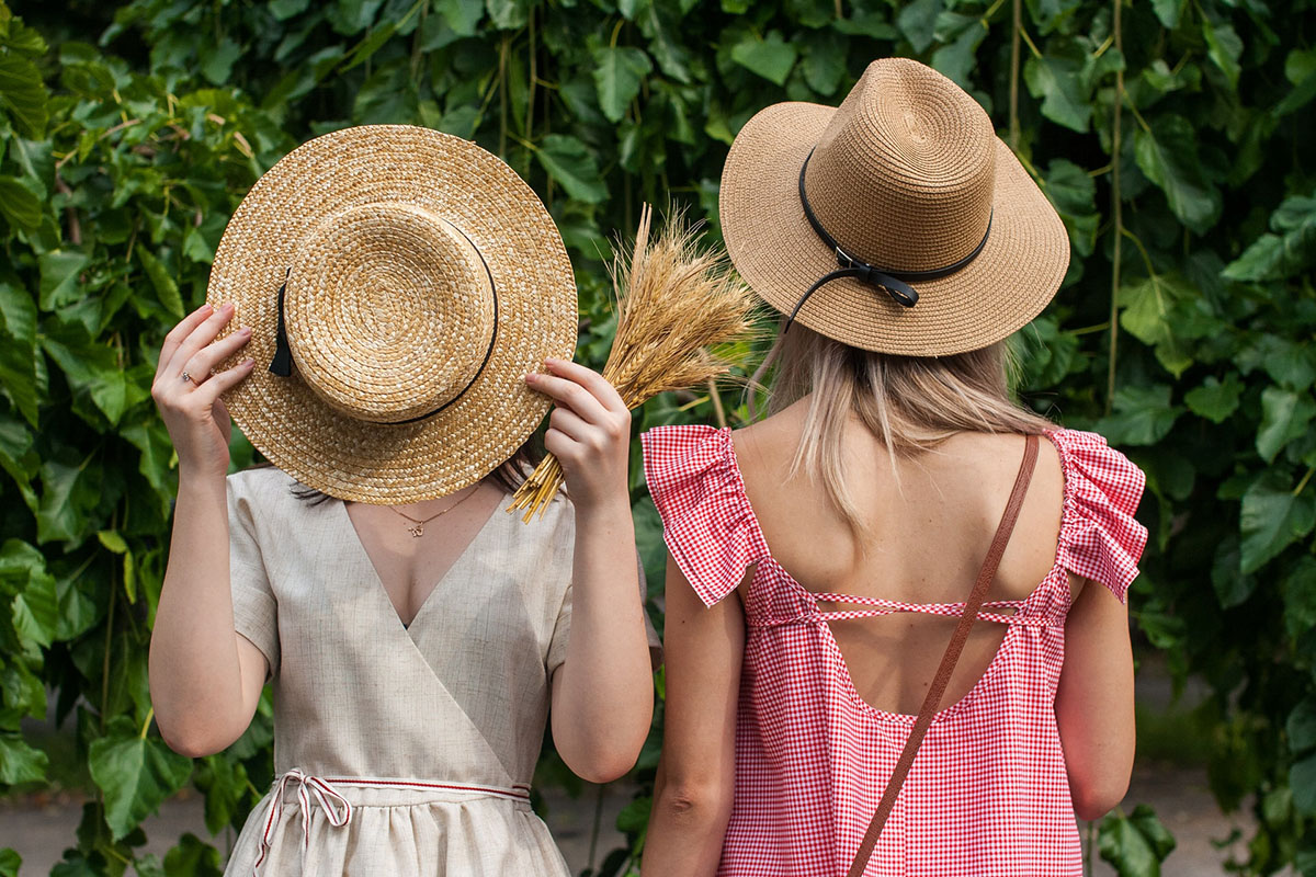 Two girls wear trendy straw hats 