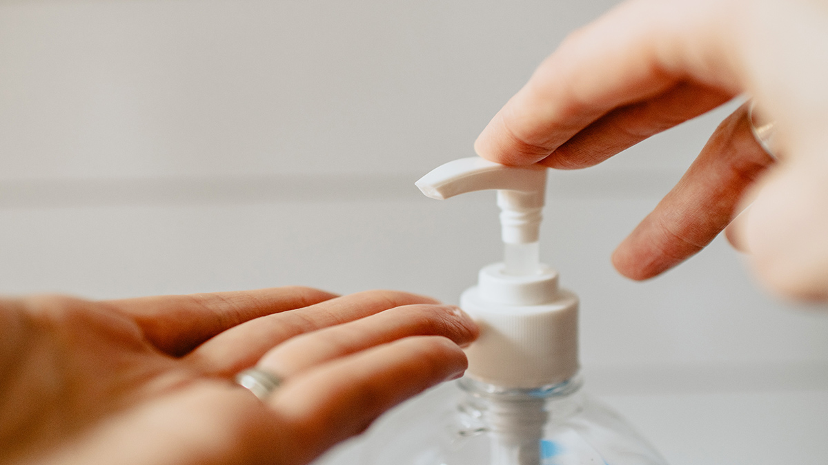 A customer washes her hands with sanitizer in a shop in Florence 