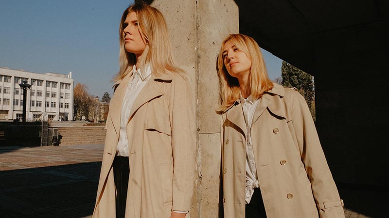 Two girls  in Florence with their beige trench coats during fall