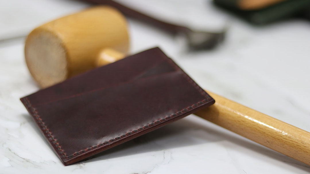 A leather card holder is being made in a workshop in Florence