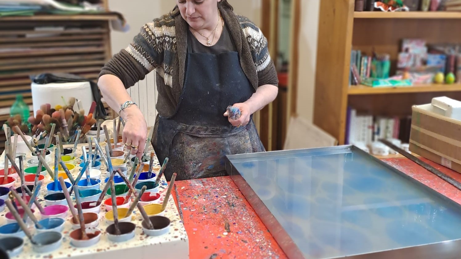 An artisan is creating some marbled paper in her shop in Florence